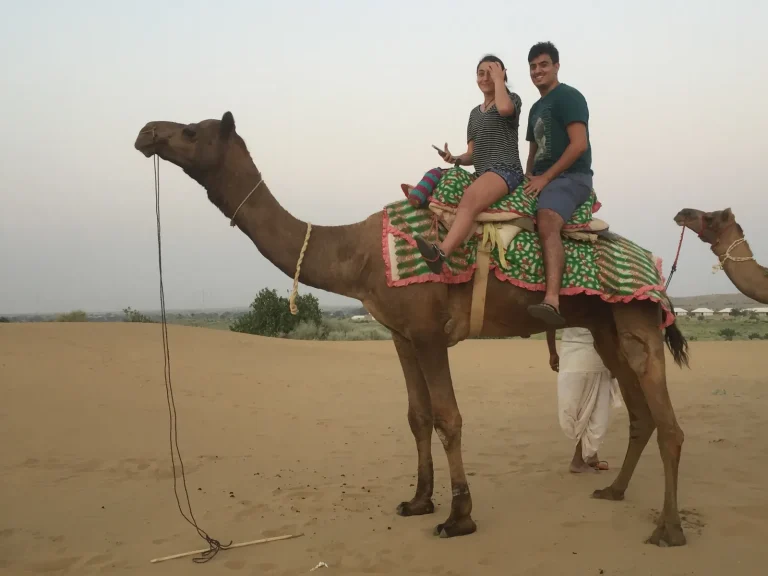 A couple on a camel ride in the Rajasthan desert on a Golden Triangle tour